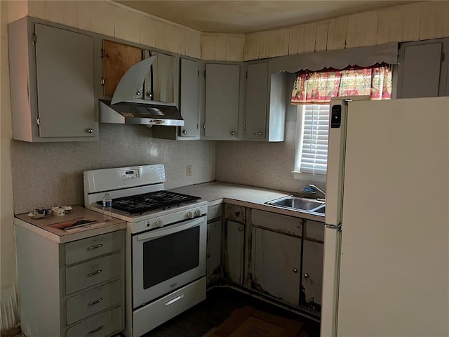 1904 E Parkview, Caruthersville, MO 63830 - kitchen with white appliances, a sink, range hood, light countertops, and gray cabinets