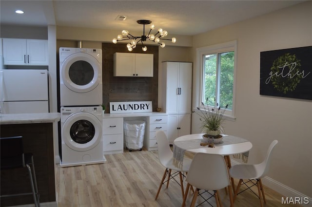 115 Lemans Ct Unit 115, Lake St Louis, MO 63367 - washroom with stacked washer / drying machine, light wood finished floors, a chandelier, baseboards, and recessed lighting