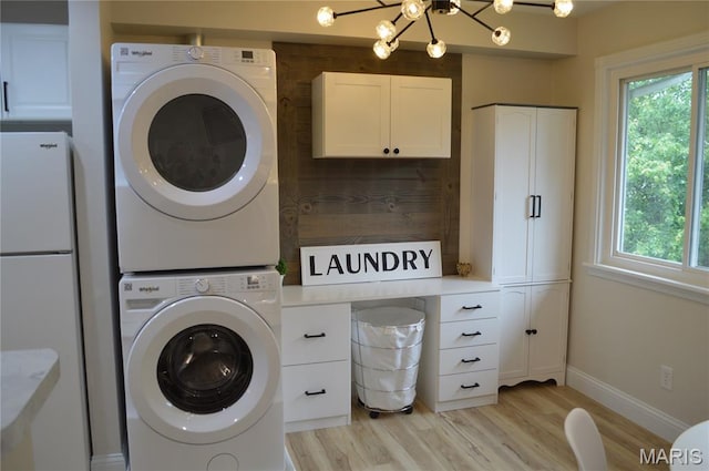115 Lemans Ct Unit 115, Lake St Louis, MO 63367 - washroom featuring stacked washing machine and dryer, healthy amount of natural light, light wood finished floors, and a chandelier