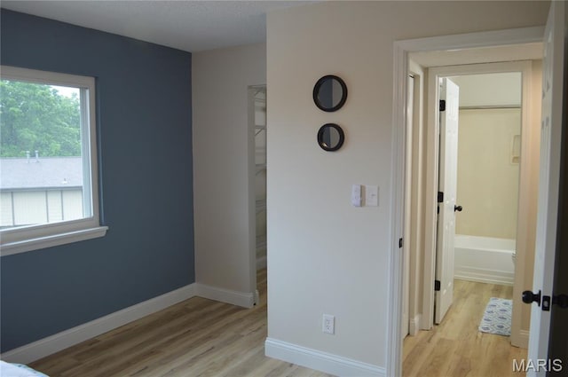 115 Lemans Ct Unit 115, Lake St Louis, MO 63367 - unfurnished bedroom featuring multiple windows, light wood-style floors, and a spacious closet