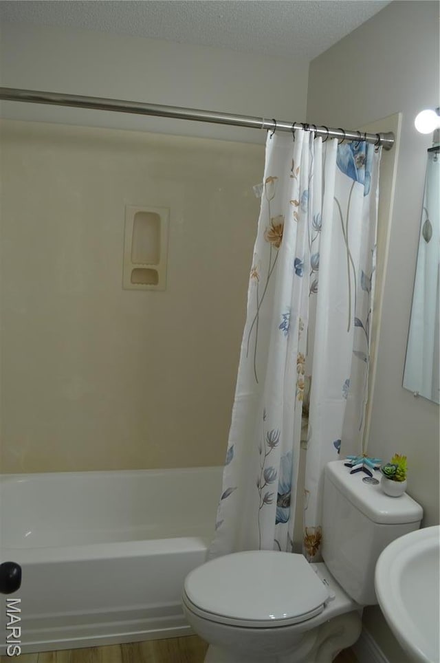 115 Lemans Ct Unit 115, Lake St Louis, MO 63367 - bathroom featuring toilet, shower / tub combo with curtain, a sink, a textured ceiling, and wood finished floors
