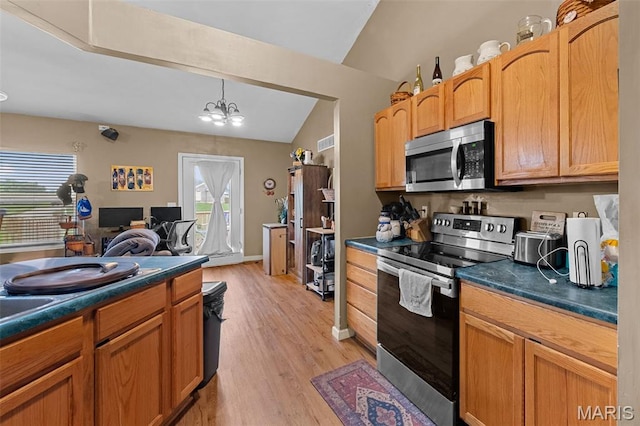 81 Berretta Ct, Wright City, MO 63390 - kitchen with appliances with stainless steel finishes, lofted ceiling, dark countertops, light wood finished floors, and a chandelier