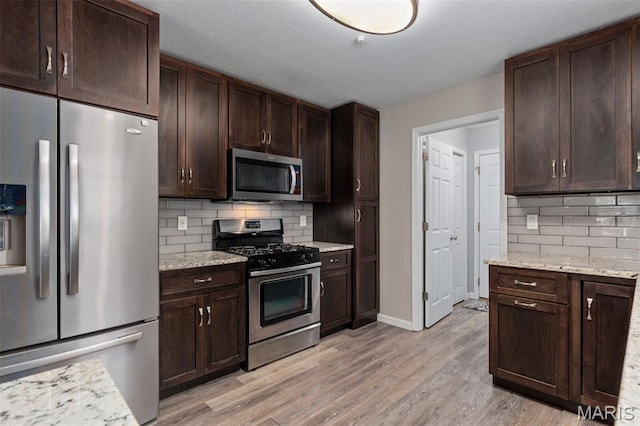 248 Prairie Grass Rd, Chatham, IL 62629 - kitchen featuring appliances with stainless steel finishes, decorative backsplash, light wood-type flooring, dark brown cabinets, and baseboards