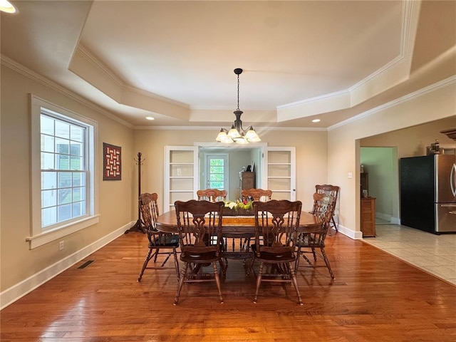 4001 W Ely Rd, Hannibal, MO 63401 - dining room featuring a raised ceiling, healthy amount of natural light, a chandelier, hardwood / wood-style flooring, and crown molding