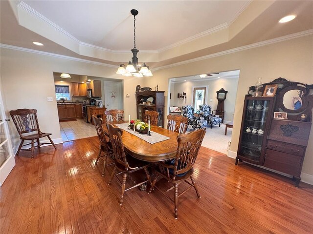 4001 W Ely Rd, Hannibal, MO 63401 - dining space with a tray ceiling, a chandelier, light wood-style floors, and crown molding
