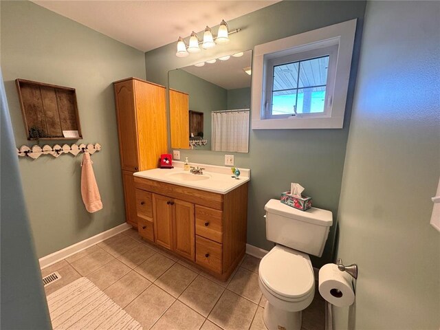 4001 W Ely Rd, Hannibal, MO 63401 - bathroom featuring toilet, tile patterned flooring, vanity, baseboards, and a shower with curtain
