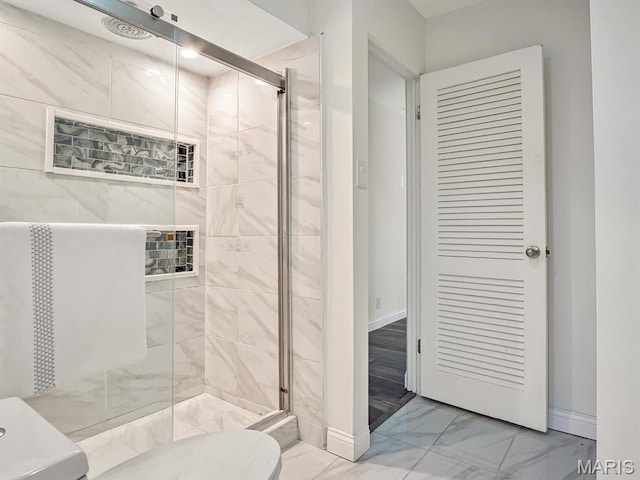 68 Carnation Dr, Belleville, IL 62221 - bathroom featuring marble finish flooring, a stall shower, and baseboards