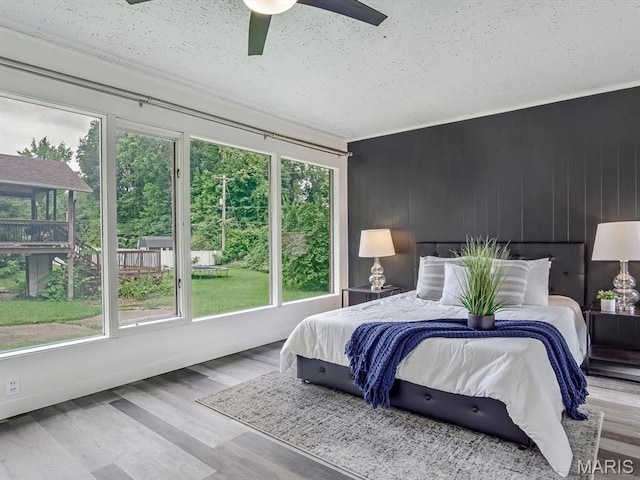 68 Carnation Dr, Belleville, IL 62221 - bedroom with a textured ceiling, wood finished floors, a ceiling fan, and wood walls