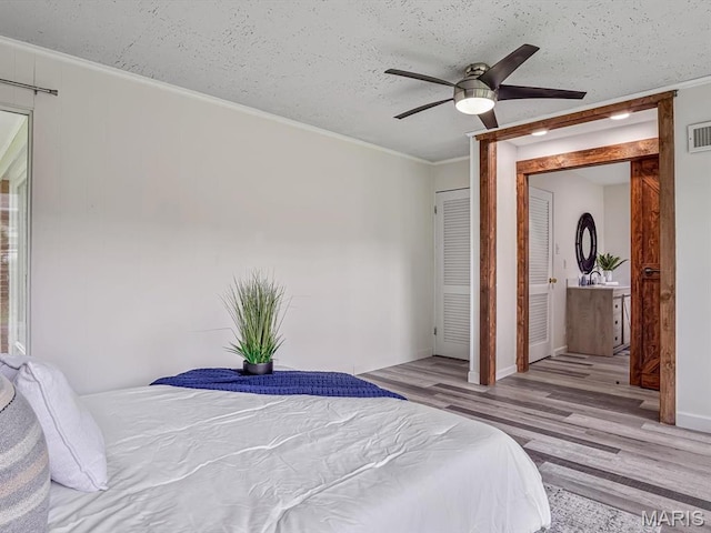 68 Carnation Dr, Belleville, IL 62221 - bedroom with light wood finished floors, ornamental molding, a textured ceiling, ceiling fan, and baseboards