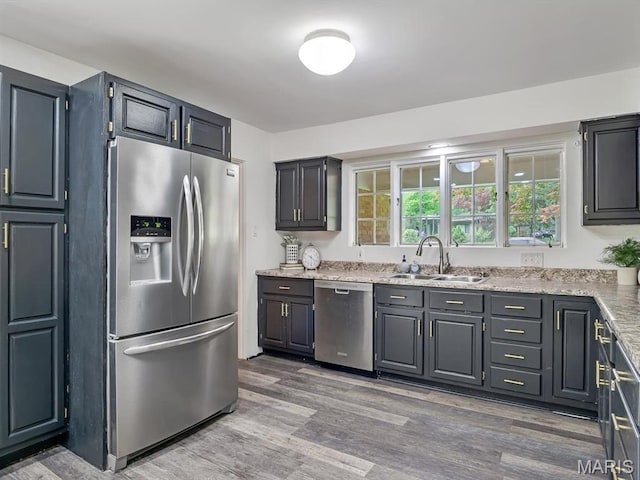 68 Carnation Dr, Belleville, IL 62221 - kitchen with stainless steel appliances, a sink, wood finished floors, and light stone countertops
