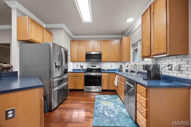 3216 Domain St, Saint Charles, MO 63301 - kitchen featuring stainless steel appliances, ornamental molding, dark wood finished floors, dark countertops, and backsplash