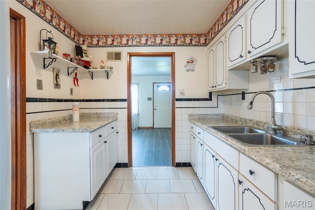 529 Maple Meadows Dr, Arnold, MO 63010 - kitchen featuring a sink, tile walls, white cabinets, light countertops, and light tile patterned floors