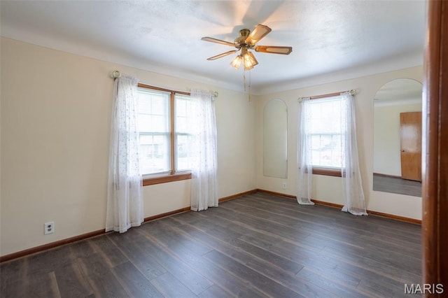 529 Maple Meadows Dr, Arnold, MO 63010 - spare room featuring arched walkways, a ceiling fan, baseboards, and dark wood-style flooring