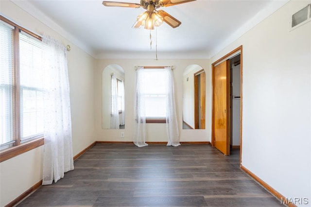 529 Maple Meadows Dr, Arnold, MO 63010 - spare room featuring a ceiling fan, arched walkways, baseboards, and dark wood-style flooring