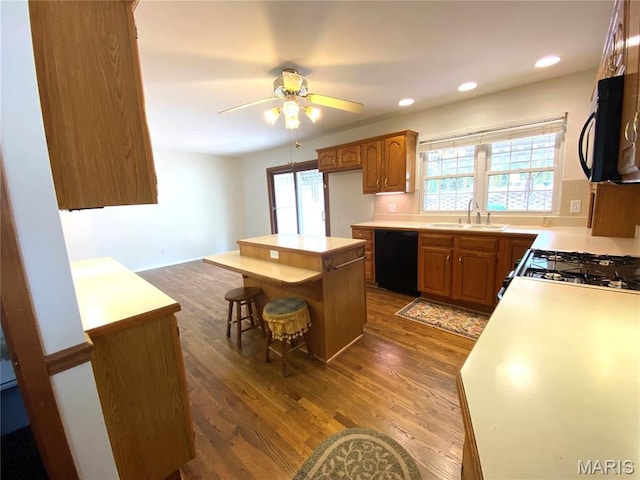 2287 Woodgrass Dr, Overland, MO 63114 - kitchen with black appliances, a sink, light countertops, wood finished floors, and recessed lighting