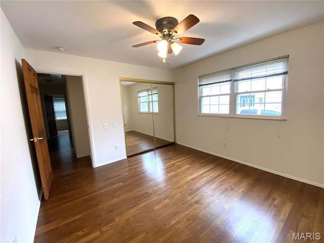 2287 Woodgrass Dr, Overland, MO 63114 - unfurnished bedroom featuring dark wood-style floors, a closet, baseboards, and ceiling fan
