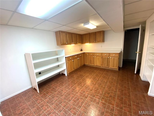 2287 Woodgrass Dr, Overland, MO 63114 - kitchen featuring brick patterned flooring, a drop ceiling, baseboards, light countertops, and open shelves