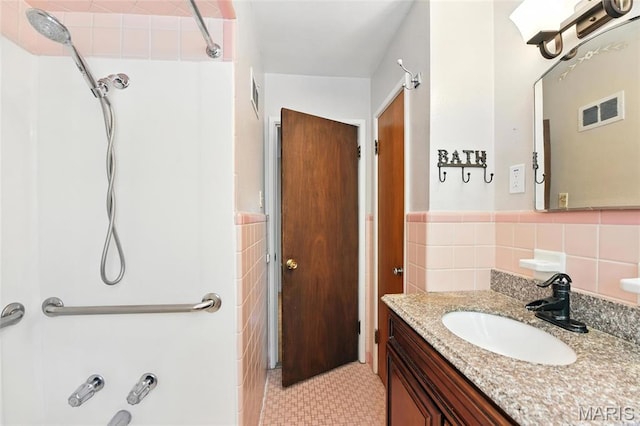 6912 Hampton Ave, Saint Louis, MO 63109 - bathroom featuring tile walls, shower / bathtub combination, vanity, and a wainscoted wall