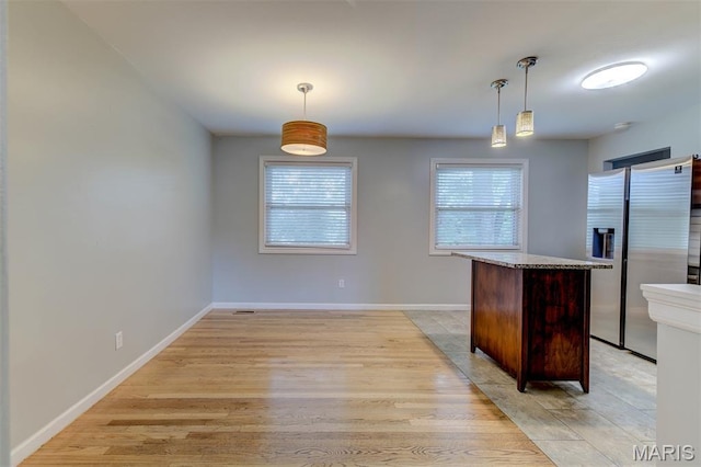36 Huck Finn Dr, Saint Charles, MO 63303 - kitchen featuring stainless steel refrigerator with ice dispenser, light wood-style flooring, decorative light fixtures, and baseboards