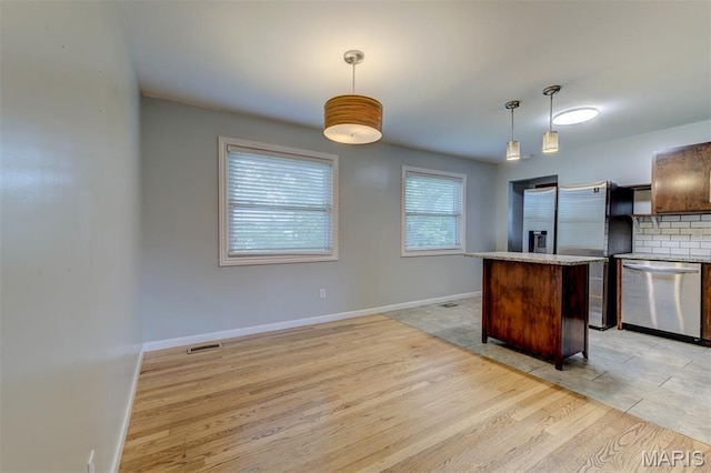 36 Huck Finn Dr, Saint Charles, MO 63303 - kitchen featuring appliances with stainless steel finishes, light wood-style floors, pendant lighting, a kitchen island, and baseboards