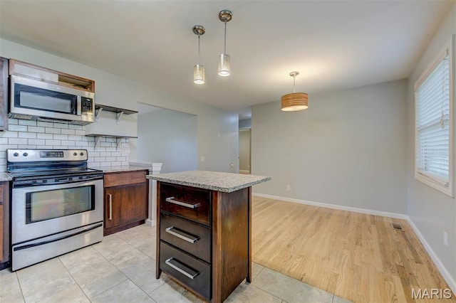 36 Huck Finn Dr, Saint Charles, MO 63303 - kitchen featuring appliances with stainless steel finishes, tasteful backsplash, light countertops, decorative light fixtures, and a kitchen island