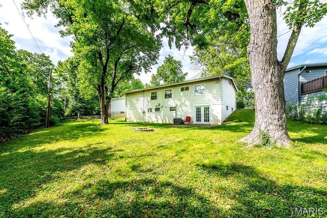36 Huck Finn Dr, Saint Charles, MO 63303 - back of property with french doors, a lawn, an outdoor fire pit, and central AC unit