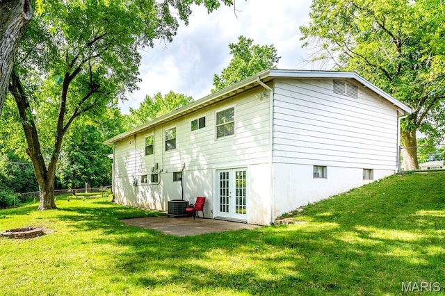36 Huck Finn Dr, Saint Charles, MO 63303 - back of property featuring french doors, a patio area, central AC unit, and a fire pit