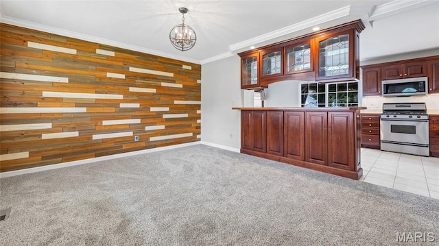 995 Sherman Ln, Florissant, MO 63031 - kitchen featuring appliances with stainless steel finishes, wooden walls, a chandelier, ornamental molding, and glass insert cabinets
