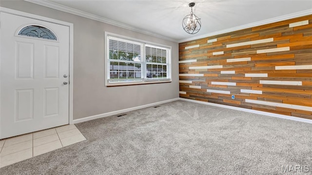 995 Sherman Ln, Florissant, MO 63031 - foyer entrance with wooden walls, a chandelier, ornamental molding, baseboards, and carpet flooring