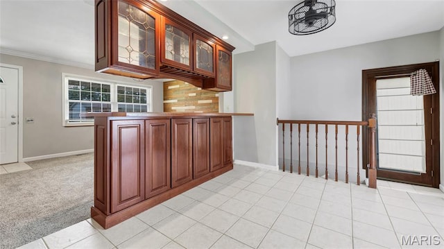 995 Sherman Ln, Florissant, MO 63031 - kitchen with glass insert cabinets, baseboards, a peninsula, backsplash, and crown molding