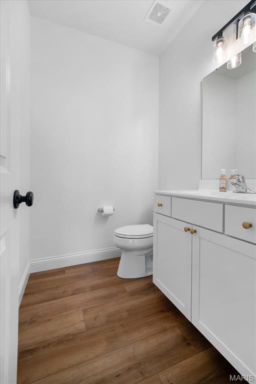 251 Randlin Dr, Ofallon, MO 63367 - half bathroom featuring vanity and wood finished floors