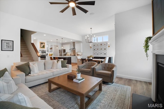 251 Randlin Dr, Ofallon, MO 63367 - living room featuring a ceiling fan, light wood-style flooring, stairs, and a chandelier