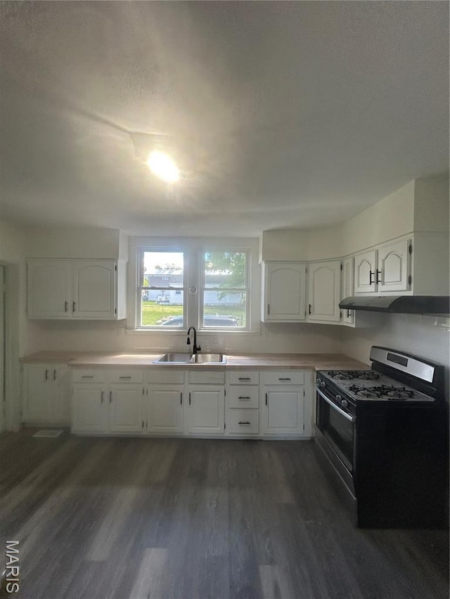 126 N Union St, Staunton, IL 62088 - kitchen featuring gas range, dark wood-style floors, under cabinet range hood, and white cabinets