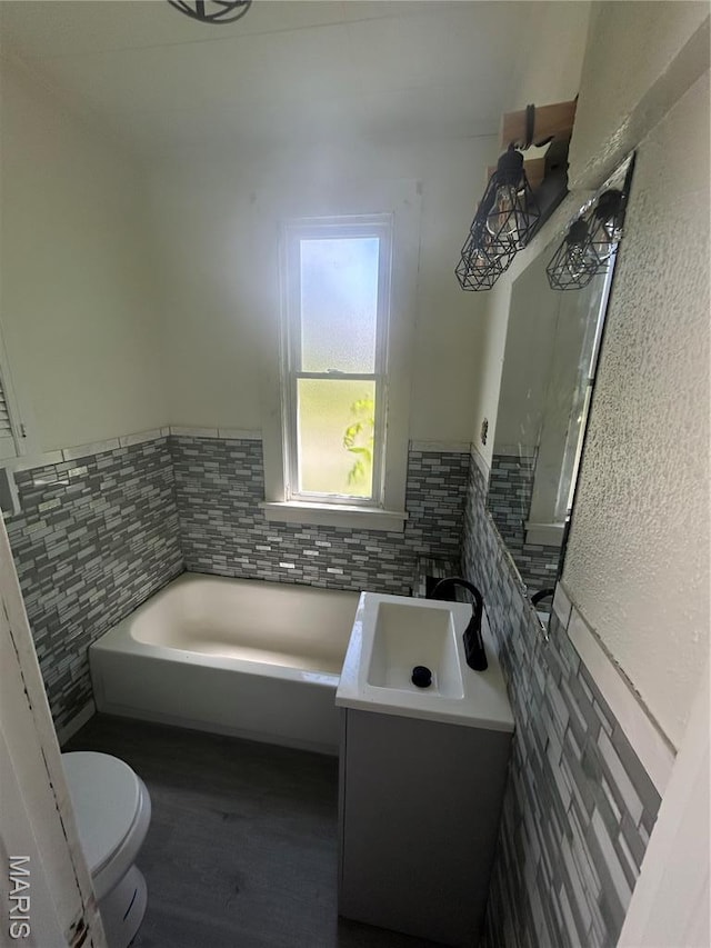 126 N Union St, Staunton, IL 62088 - full bath with a garden tub, vanity, a wainscoted wall, wood finished floors, and tile walls