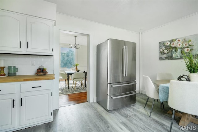 126 N Union St, Staunton, IL 62088 - kitchen with freestanding refrigerator, butcher block counters, light wood-type flooring, and white cabinetry