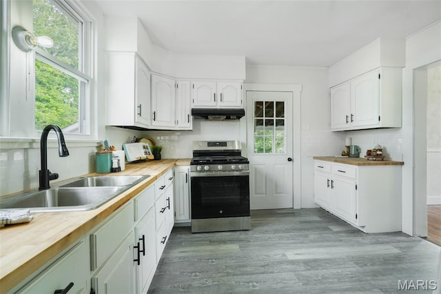 126 N Union St, Staunton, IL 62088 - kitchen with stainless steel gas stove, under cabinet range hood, wood counters, backsplash, and plenty of natural light