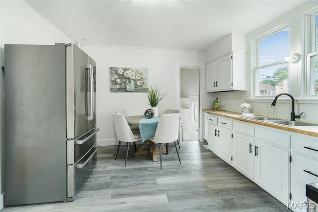 126 N Union St, Staunton, IL 62088 - kitchen with freestanding refrigerator, white cabinetry, light wood-type flooring, and tasteful backsplash