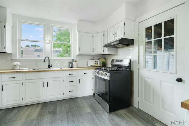 126 N Union St, Staunton, IL 62088 - kitchen with stainless steel gas range, under cabinet range hood, wood finished floors, decorative backsplash, and white cabinetry