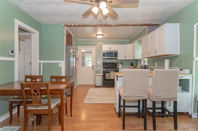 870 Walnut St, Newburg, MO 65550 - dining area featuring a ceiling fan, light wood finished floors, and a textured ceiling