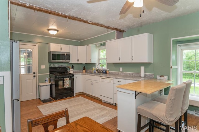 870 Walnut St, Newburg, MO 65550 - kitchen with stainless steel appliances, a sink, a ceiling fan, white cabinets, and a peninsula