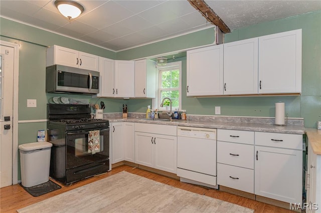870 Walnut St, Newburg, MO 65550 - kitchen with black range with gas stovetop, dishwasher, stainless steel microwave, a sink, and white cabinetry