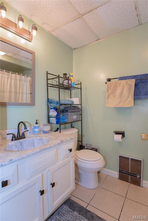870 Walnut St, Newburg, MO 65550 - bathroom featuring tile patterned flooring, toilet, vanity, a drop ceiling, and baseboards