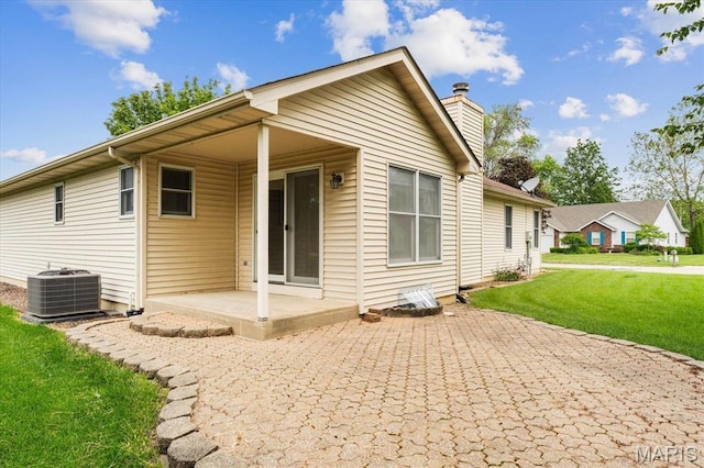 1500 Birch Ct, Edwardsville, IL 62025 - back of house featuring central AC, a patio, a chimney, and a lawn