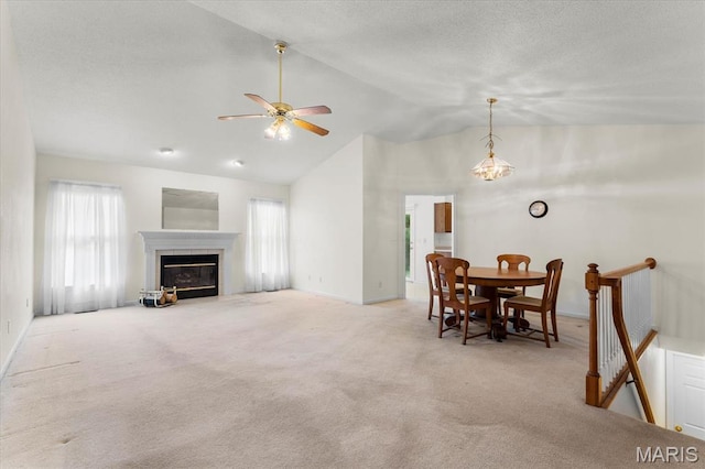 1500 Birch Ct, Edwardsville, IL 62025 - carpeted living area with vaulted ceiling, a ceiling fan, baseboards, a tiled fireplace, and a textured ceiling