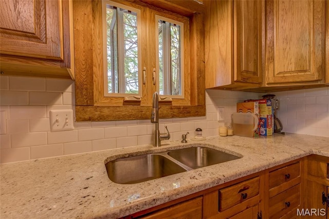 31511 Bowman Station Rd, Jerseyville, IL 62052 - kitchen featuring a sink, tasteful backsplash, light stone countertops, and brown cabinets