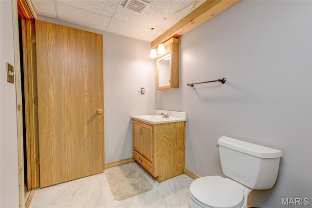 31511 Bowman Station Rd, Jerseyville, IL 62052 - half bathroom with vanity, toilet, marble finish flooring, baseboards, and a drop ceiling