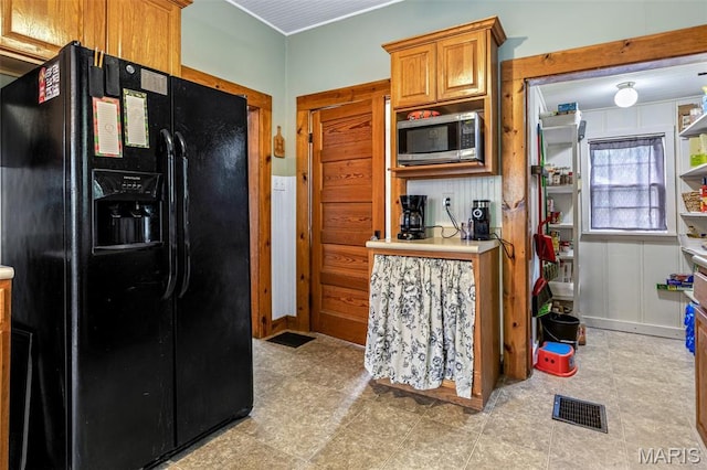 805 W Columbia St, Farmington, MO 63640 - kitchen featuring black fridge, stainless steel microwave, light countertops, and brown cabinetry