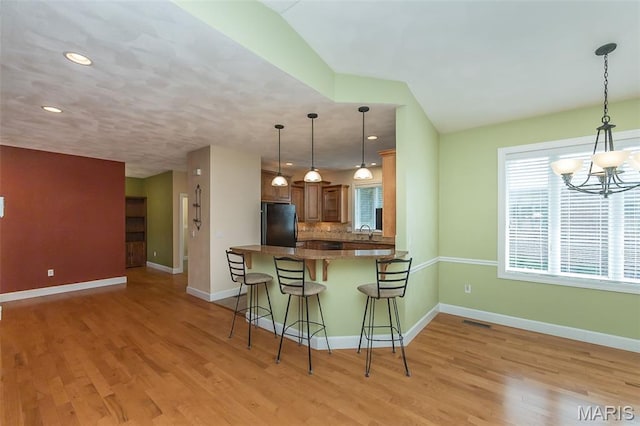 1812 Carrington Way, Belleville, IL 62226 - kitchen with freestanding refrigerator, a sink, a chandelier, light wood finished floors, and a breakfast bar