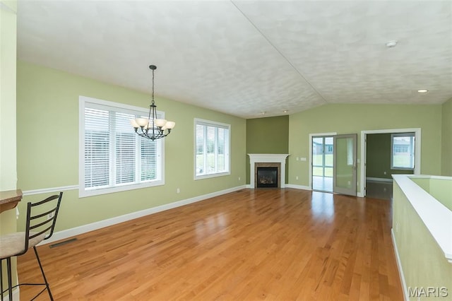 1812 Carrington Way, Belleville, IL 62226 - unfurnished living room with light wood-style flooring, plenty of natural light, a chandelier, baseboards, and lofted ceiling