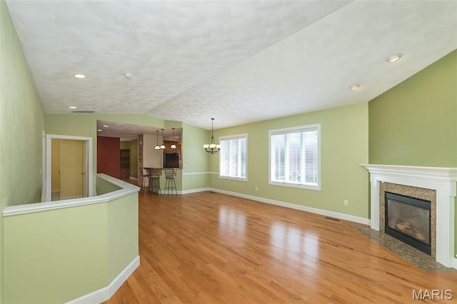 1812 Carrington Way, Belleville, IL 62226 - unfurnished living room featuring a premium fireplace, light wood-style flooring, a chandelier, baseboards, and lofted ceiling